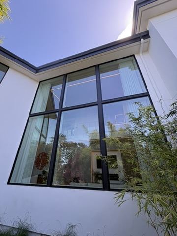 Floor-to-ceiling black-framed modern windows cleaned to a clear finish