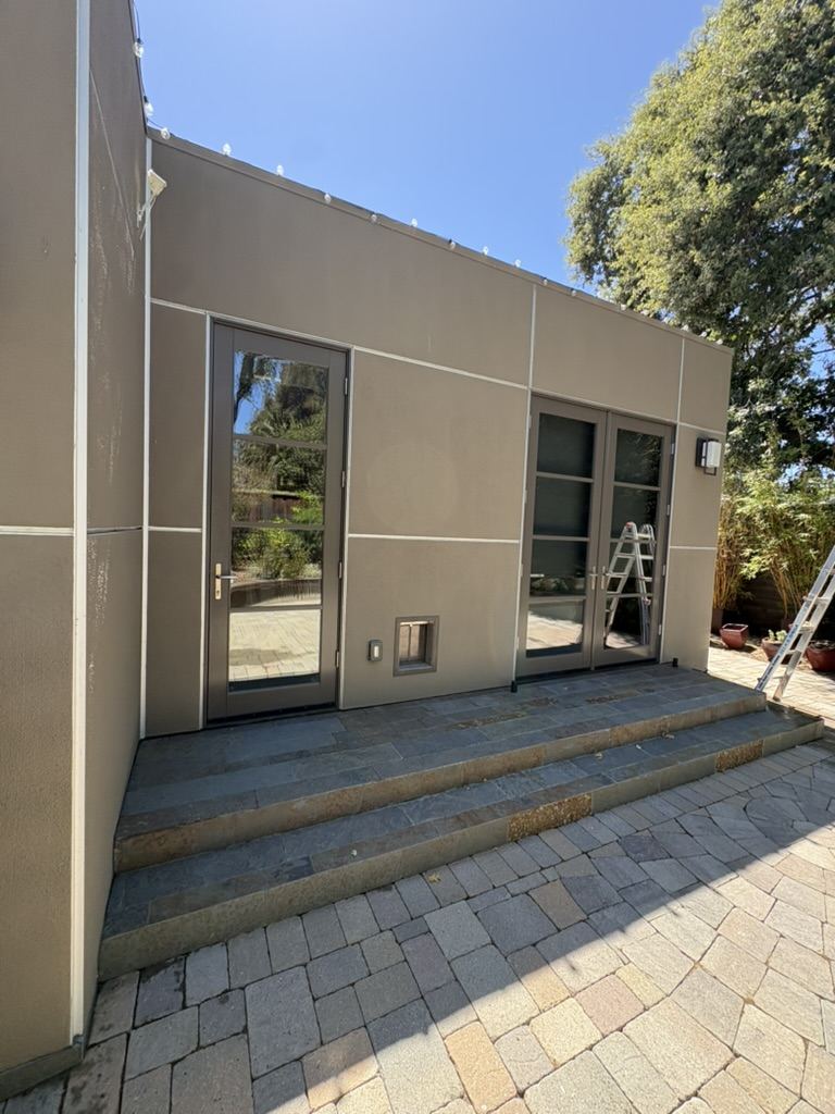 Modern stucco home with glass doors and slate steps after exterior window cleaning