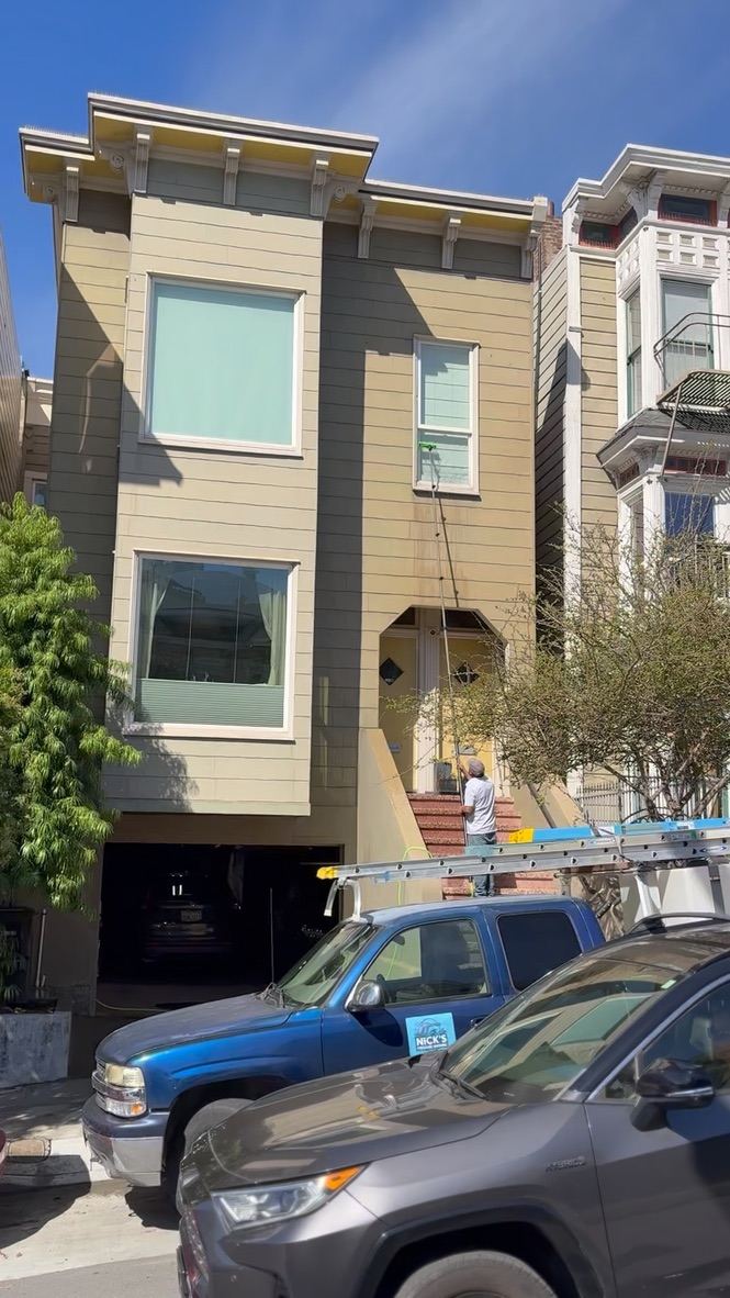Technician cleaning upper-story windows of a San Francisco home with a water-fed pole